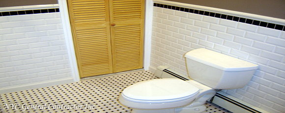 Showing you the bottom half of the previous photo - Notice how the floor tiles have navy blue accents to compliment the wall tiles - Complete with a new Kohler toilet bowl and radiant hot water heating underneath... makes this bathroom the best seat in the house! am I right Dave?... General Contractor